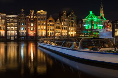 AMSTERDAM - 14 Aralık 2019: Damrak Kanalı 'ndaki ünlü dans kanalı evleri 