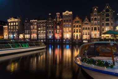 AMSTERDAM - 14 Aralık 2019: Damrak Kanalı 'ndaki ünlü dans kanalı evleri 