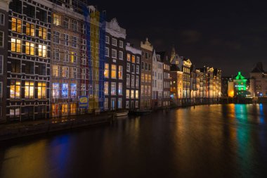 AMSTERDAM - 14 Aralık 2019: Damrak Kanalı 'ndaki ünlü dans kanalı evleri 