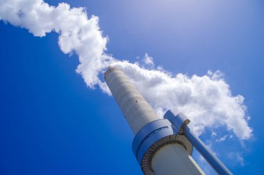 Büyük, dumanlı bir elektrik santrali bacası.