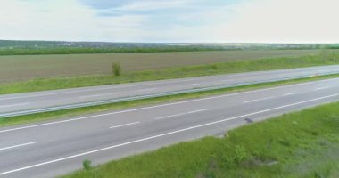 Çok şeritli otoban manzaralı. Büyük bir otoyolun üzerinde uçuyor. Modern bir yol manzarası üzerinde giden arabalar