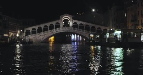 Rialto Bridge At Night, Venezia, Olaszország. A velencei csatorna éjszakai kerete, Rialto híd a Grand Canal felett — Stock videók