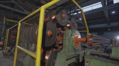 Makine bir fabrikada bakır telleri karıştırıyor. Kablo üretimi için bitki. Bakır kabloyu karıştırıyorum. Bakır kabloya yakın çekim.