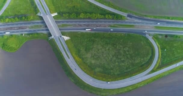 European road. Crossing roads. Two highways intersect and become one road. Highways with cars top view. Green meadows around the big road. — Stock Video