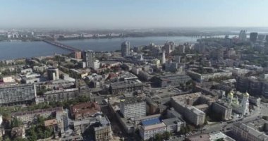 Dnipro şehrinin merkezinde bir hava uçuşu. Dinyeper nehrinde bir şehir. Nehir kenarındaki eski şehrin üzerinde uçuyor. Doğu Avrupa kenti havadan.
