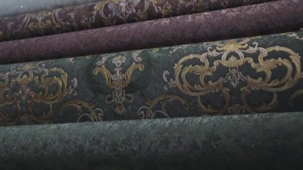 Wallpaper with patterns. Stands with rolls of wallpaper samples in the store. Stands with new samples. Rolls with wallpaper. Closeup — Stock Video