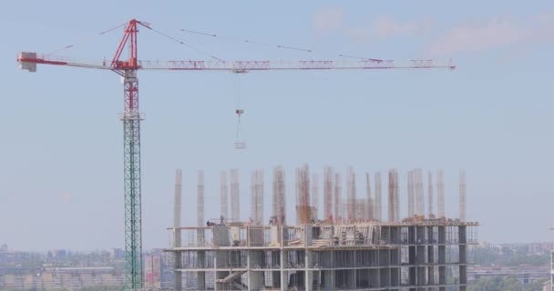 Construction of a multi-storey residential building. Tower crane at a construction site. Construction crane at a construction site — Stock Video