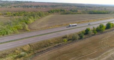Beyaz yakıt kamyonu otoyolda, yakıt kamyonu güneşli havada otoyolda ilerliyor.