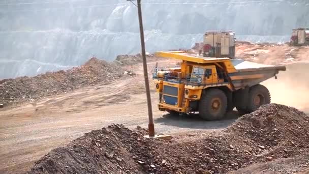 Вантажівка для сміття їде через кар'єр. Великі гірничі сміттєвози. Велика вантажівка на вугільній шахті. Жовтий сміттєвоз у вугільній шахті.. — стокове відео