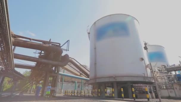 Grote opslagtanks in de fabriek. Buiten een moderne fabriek. Witte opslagtanks voor vloeistoffen in een moderne fabriek — Stockvideo