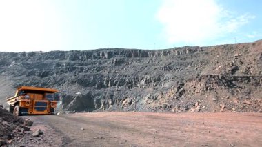 Büyük bir maden kamyonu. Kömür madeninde büyük bir çöp kamyonu. Kömür madenindeki sarı çöp kamyonu. Çöp kamyonu taş ocağından geçiyor..