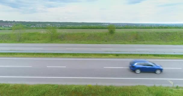 LKW auf der Autobahn von der Drohne aus gesehen. LKW fährt auf moderner Autobahn um grünen Rasen von oben gesehen — Stockvideo