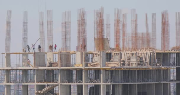 Lugar de construcción. Los trabajadores están construyendo un edificio de varios pisos. Construyendo una casa — Vídeos de Stock