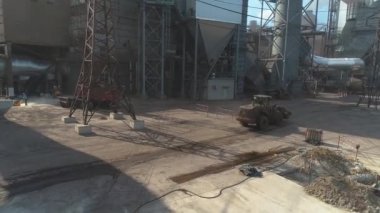 Fabrikada yeni bir atölye inşaatı. Bir fabrikadaki inşaat alanının üzerinden uçmak. İnşaat makineleri sitenin üst görünümünde