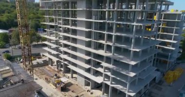 Bir konut kompleksinin inşaatı. Çok katlı bir bina havadan görüntüsü inşa ediliyor. Bir apartmanın inşaat sahasına yakın bir yerde.