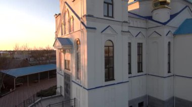 Gün batımında kilisenin üzerinden uç. Güzel bir ortodoks kilise drone manzarası. Gün batımında güzel bir kilise. Ortodoks Kilisesi