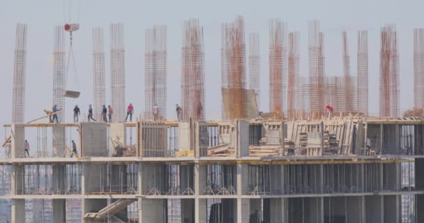 Proces výstavby obytné budovy. Výstavba vícepodlažní budovy. Lidé pracují na staveništi.. — Stock video