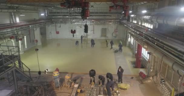 Lavoratori del cantiere. I lavoratori fanno il pavimento nel laboratorio dello stabilimento. Costruzione di una nuova officina nello stabilimento — Video Stock