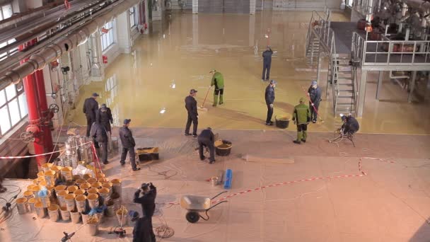 Construcción de un nuevo taller en la planta. Trabajadores en la obra. Los trabajadores hacen el piso en el taller de la planta. — Vídeo de stock