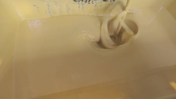Eine Nahaufnahme von gelber Farbe, die in einem Eimer gerührt wird. Farbe im Eimer rühren. — Stockvideo