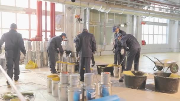 Agitar la pintura en un barril, preparando el material para su uso en una obra de construcción. Trabajador remover la pintura en un cubo — Vídeos de Stock