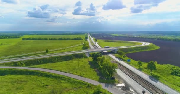 Road junction on a modern highway aerial view. Modern road, around the green meadows — Stock Video
