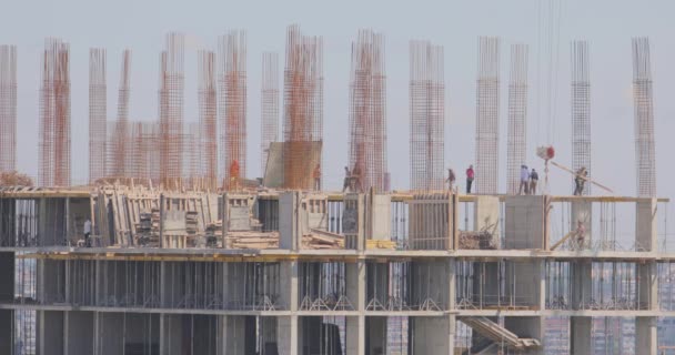 O processo de construção de um edifício residencial. Construção de um edifício de vários andares. As pessoas estão trabalhando em um canteiro de obras. — Vídeo de Stock