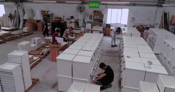 Assemblage de meubles dans une usine, assemblage de meubles dans une usine chinoise. Encerclant le drone autour des gens qui recueillent des meubles — Video