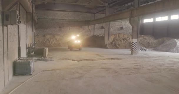 Bulldozer amarillo hace el trabajo dentro del edificio, bulldozer amarillo con la arena en el cubo — Vídeos de Stock