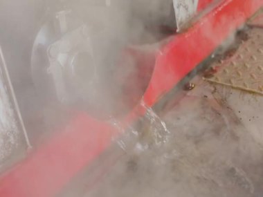 Endüstriyel suyun boşaltılması. Tankın kimyasal temizliğinden sonra atık su. Su borudan akıyor, sıcak su buharlaşıyor.