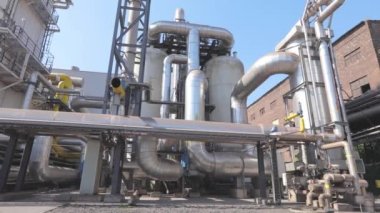 Fabrikada bir sürü büyük parlak borular var. Büyük metal parlak borular. Endüstri dışı