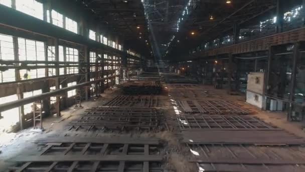 Dentro del taller para la producción de vigas de acero. Se extiende dentro de un gran almacén con espacios en blanco de metal. Una envergadura dentro de un gran taller de metal. — Vídeo de stock