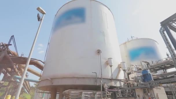 Grandes tanques de almacenamiento en la fábrica. Exterior de una fábrica moderna. Tanques de almacenamiento blancos para líquidos en una fábrica moderna — Vídeos de Stock