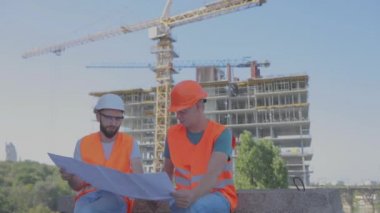 İnşaat alanının arka planında mühendisler var. Bir apartman inşaatının arka planında çalışanlar