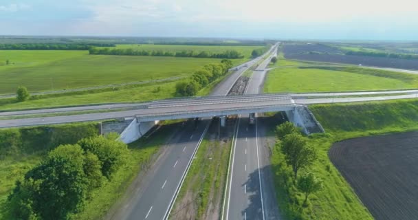 Trafikutbyte ovanifrån. Bilar kör längs motorvägen, ovanifrån. Flyg över en vägkorsning Bilar kör längs motorvägen utanför staden — Stockvideo