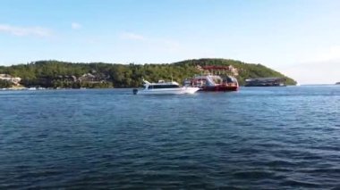 Tekne Bali 'de dalgalar boyunca hızla yüzüyor, çok fazla su sıçrıyor. Bir motorlu tekne dalgalar boyunca yüzüyor, kenarlarında daha fazla sprey var..