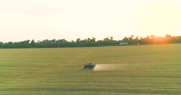 Verwerking van een tarweveld met pesticiden. Zicht van een drone. Tractor behandelt tarweveld met pesticiden — Stockvideo