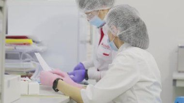 Hastanedeki doktor not alıyor. Laboratuvardaki laboratuvar çalışanları. Modern bir tıp laboratuarında çalışma süreci