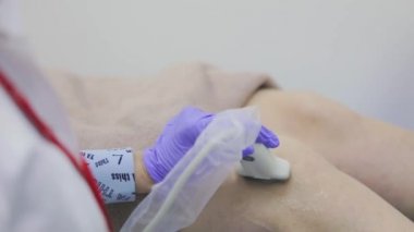 Ultrason makinesiyle insan dizinin incelenmesi. Doktor diz ultrasonu yapıyor..