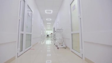 Kamera hastanenin boş koridoru boyunca döner. Modern bir hastanenin koridorları. Kliniğin boş, parlak koridoru. Modern bir kliniğin içinde.