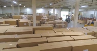 Fabrikada kutularla dolu bir depo. Büyük bir depodaki bir forklift kutuları taşır. Fabrikada bitmiş ürünlerle dolu büyük bir depo..