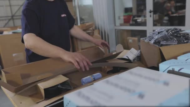 Förpackning av färdiga varor i en kartong. Arbetstagare packar färdiga produkter i en låda — Stockvideo