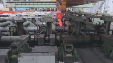 Taşıyıcı hattındaki sıcak metal. Kırmızı sıcak metal. Bir metalurji fabrikasında rulo metal üretimi