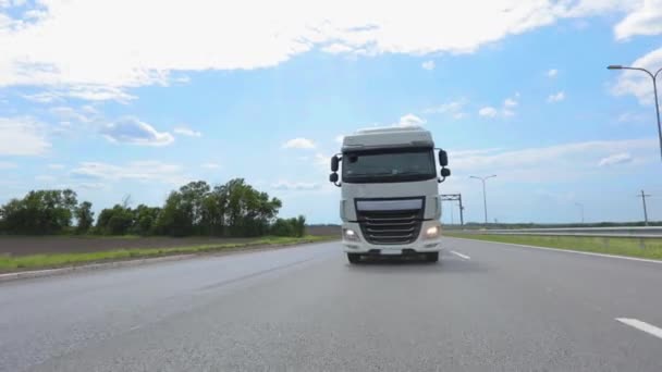 Un camión moderno está conduciendo por la carretera. Transporte de mercancías. Servicios logísticos. Camión blanco conduciendo por la carretera. Un camión cisterna conduciendo por la carretera — Vídeo de stock