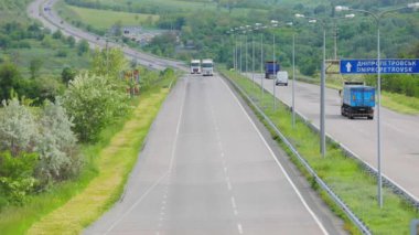 Otoyolda giden tank kamyonları. Kamyonlar yol boyunca gidiyor. Otoyol manzarası boyunca giden kamyonlar. Banliyö yolunda kamyonlar sürüyor.
