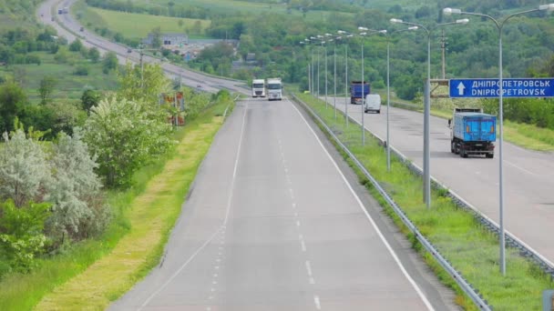 Ciężarówki cysterny jadące po autostradzie. Ciężarówki jadą wzdłuż drogi. Ciężarówki jadące wzdłuż autostrady widok z przodu. Ciężarówki jadą podmiejską autostradą. — Wideo stockowe