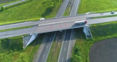 Trafik kavşağı üst görünümü değiştir. Arabalar otoban boyunca gidiyor, manzarası çok güzel. Bir yol kavşağının üzerinden uçuyorlar. Arabalar şehrin dışındaki otoyol boyunca ilerliyorlar.
