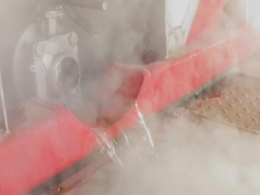 Endüstriyel suyun boşaltılması. Tankın kimyasal temizliğinden sonra atık su. Su borudan akıyor, sıcak su buharlaşıyor.