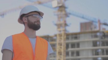Genç bir mühendis kameraya yakından bakıyor. Stryke 'taki mühendis. İnşaatçı kameraya bakar.