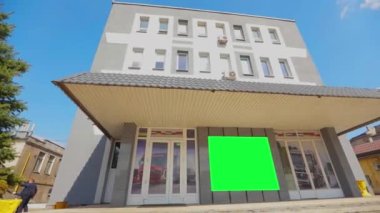 Yeşil ekranlı ofis binası. Reklam pankartı yeşil ekranda. Reklamlarınızı eklemek için yeşil ekranlı bir ofis binası..